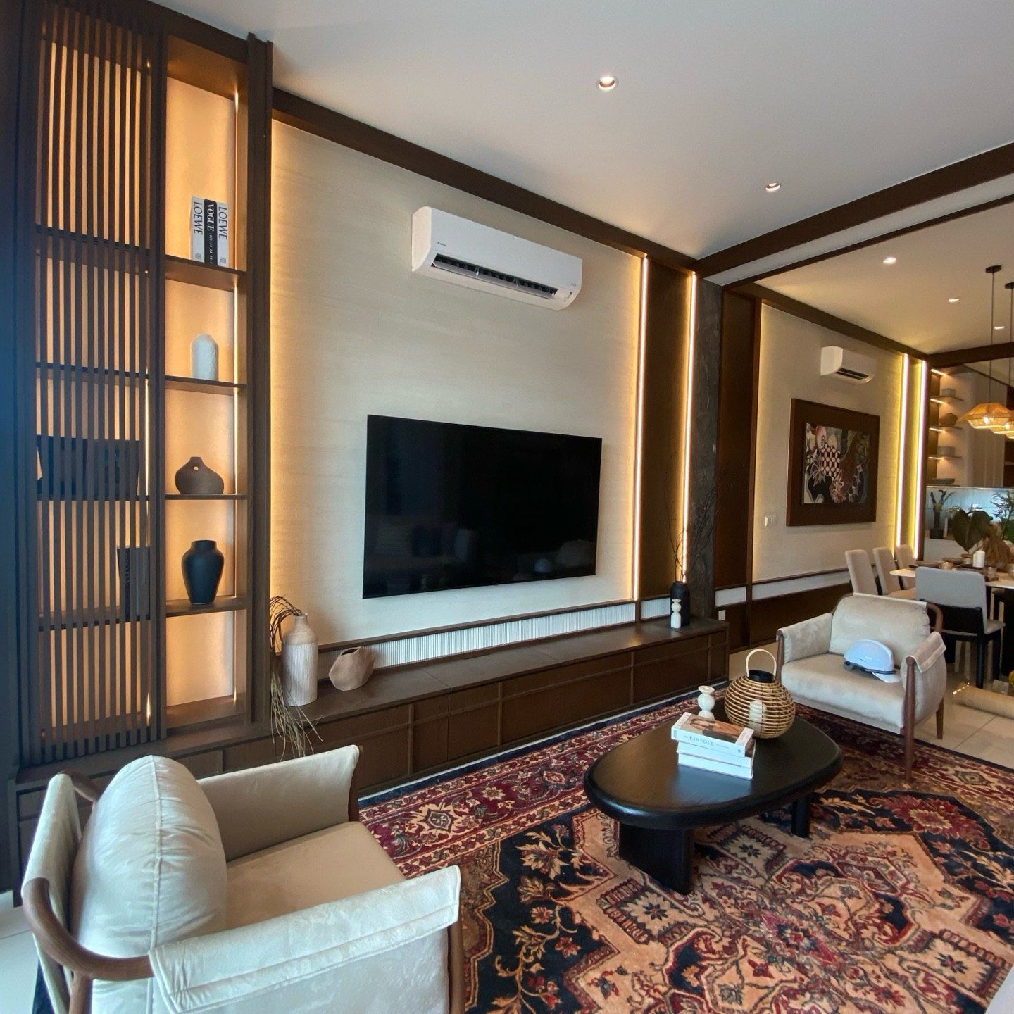 A show unit living room with timber shelves, a textured feature wall and a patterned rug