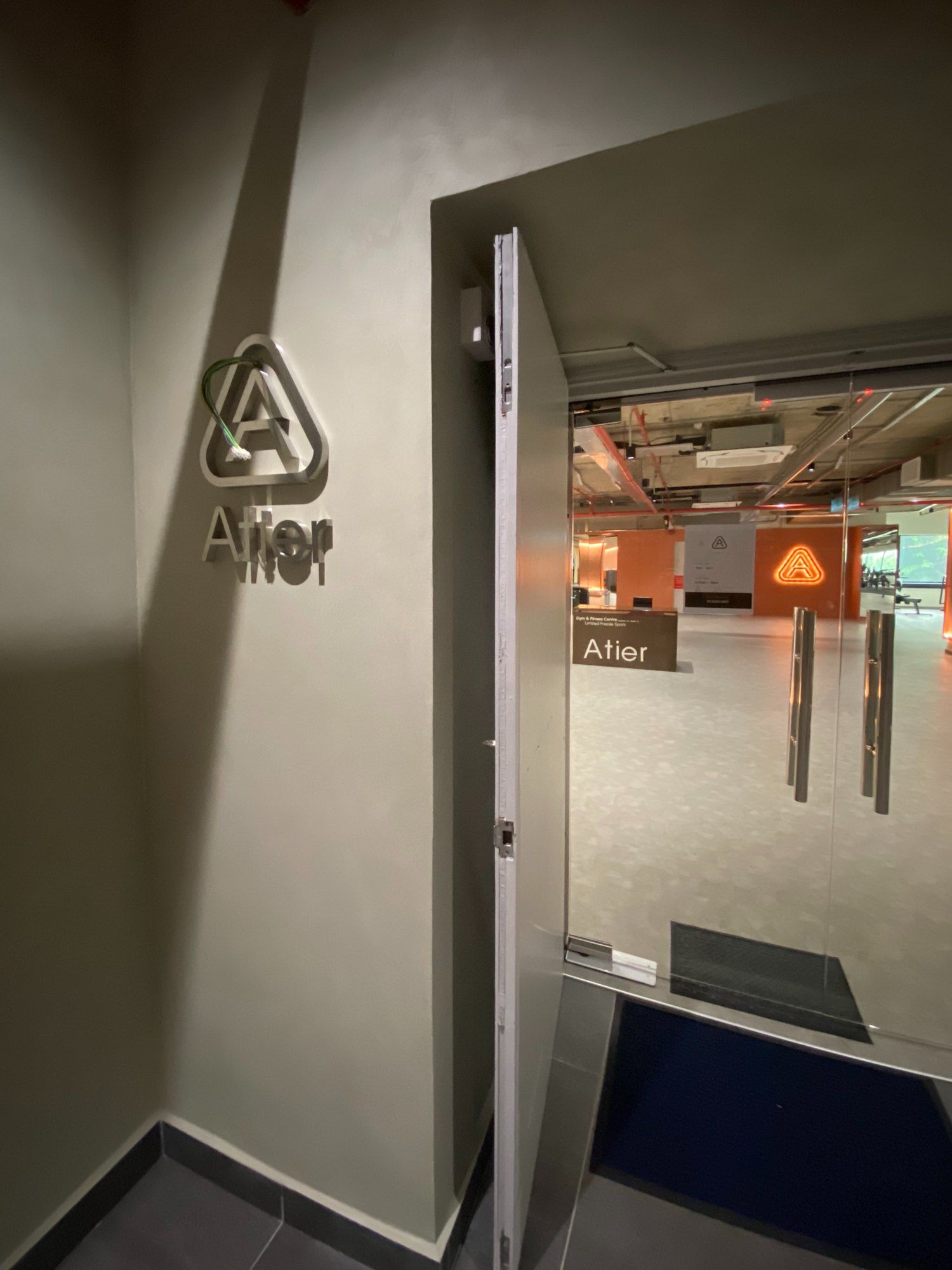 A lift lobby with smooth grey sleek plaster walls and a stainless steel door frame