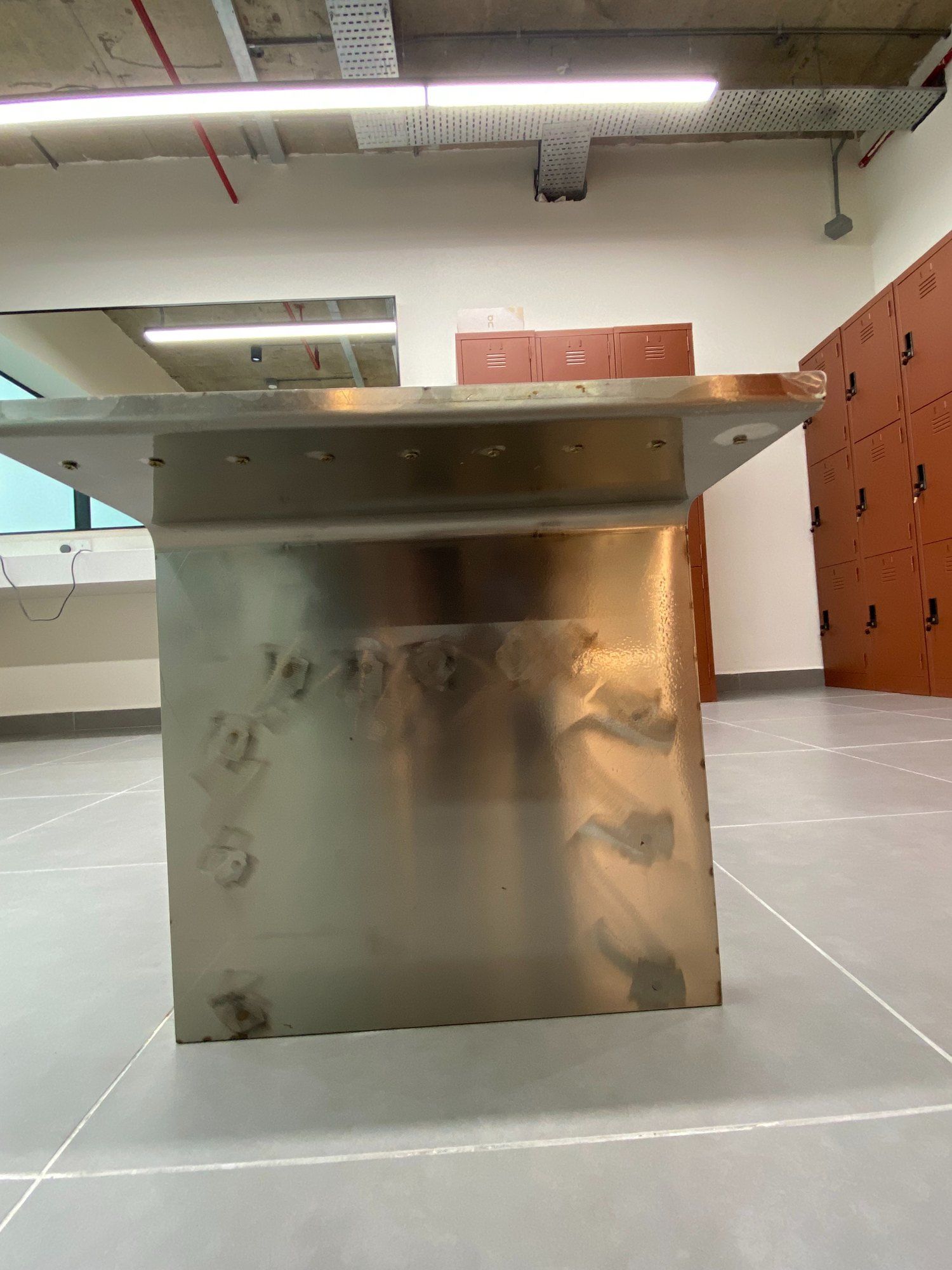 A stainless steel counter panel with a damaged area being repaired